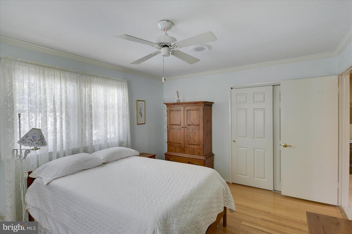 7516 Inzer Street Springfield, VA 22151 - Photo 14 of 30 a bedroom with a large bed and a chandelier