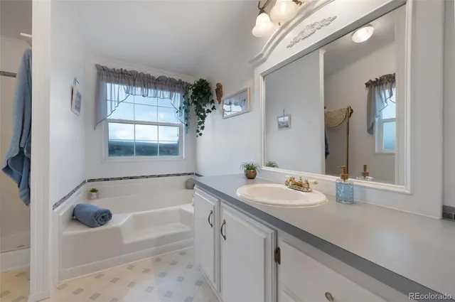 a bathroom with a tub sink and mirror