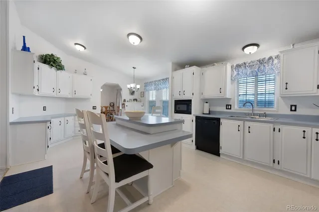 a kitchen with white cabinets and appliances