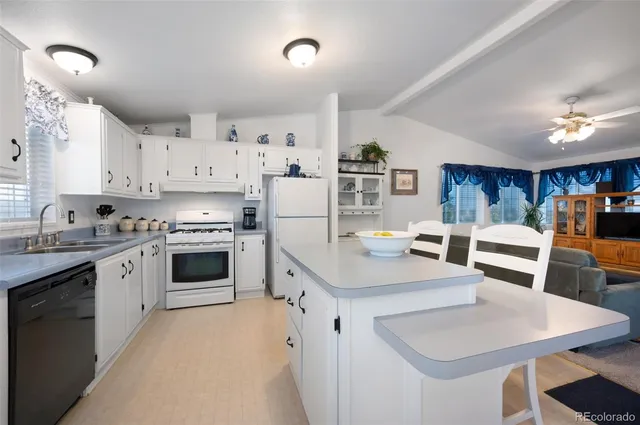 a kitchen with white cabinets and white appliances