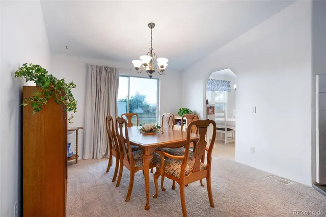 a view of a dining room with furniture and chandelier