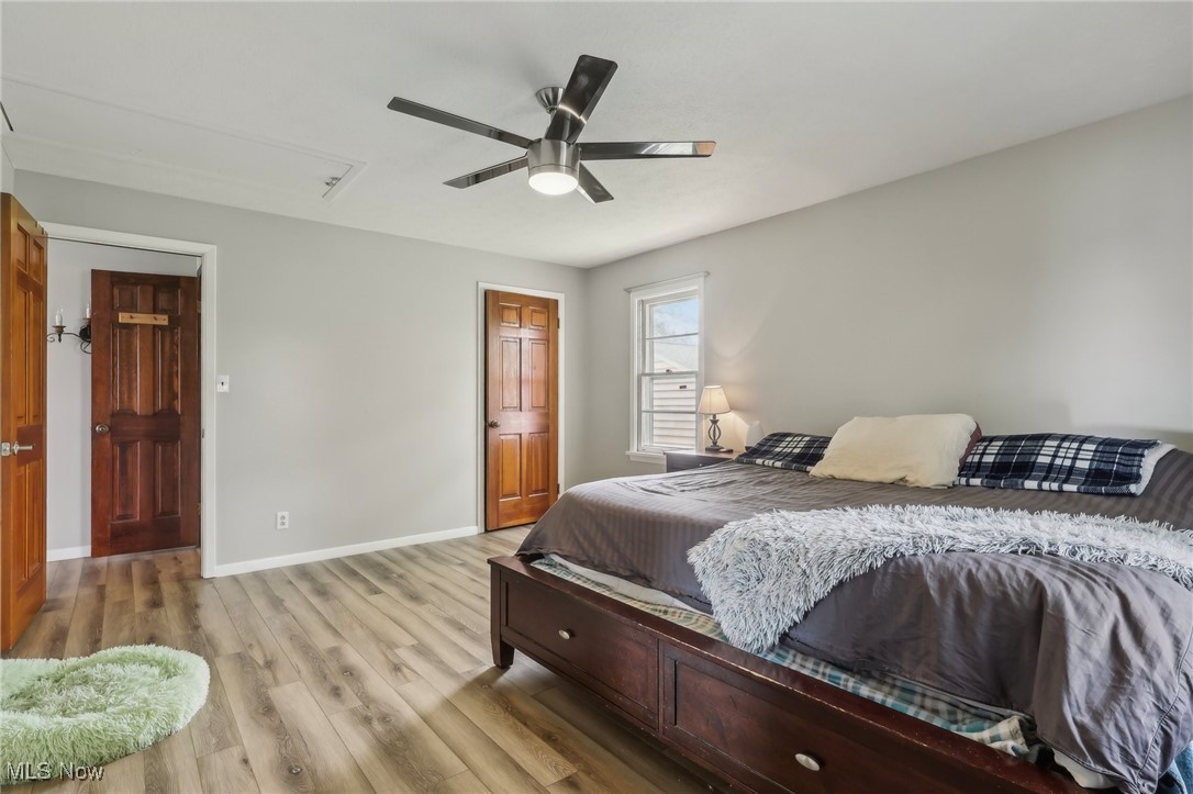 13676 Whitney Road Strongsville, OH 44136 - Photo 20 of 46 Bedroom with 2 closets, a ceiling fan, light wood-style flooring, and baseboards