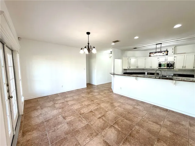 a view of a kitchen with kitchen island a sink stainless steel appliances and cabinets