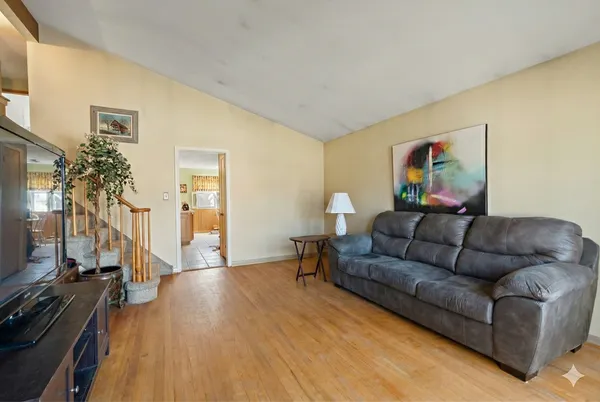 a living room with furniture and a flat screen tv with wooden floor