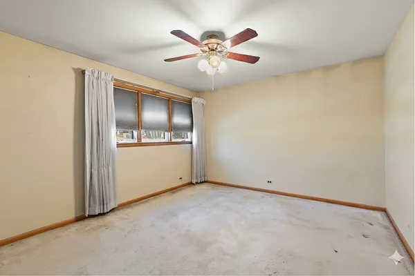 an empty room with closet and fan