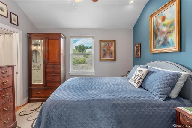 a bedroom with a large bed and a painting on the wall