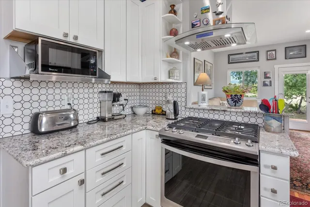 a kitchen with stainless steel appliances granite countertop a sink stove and microwave