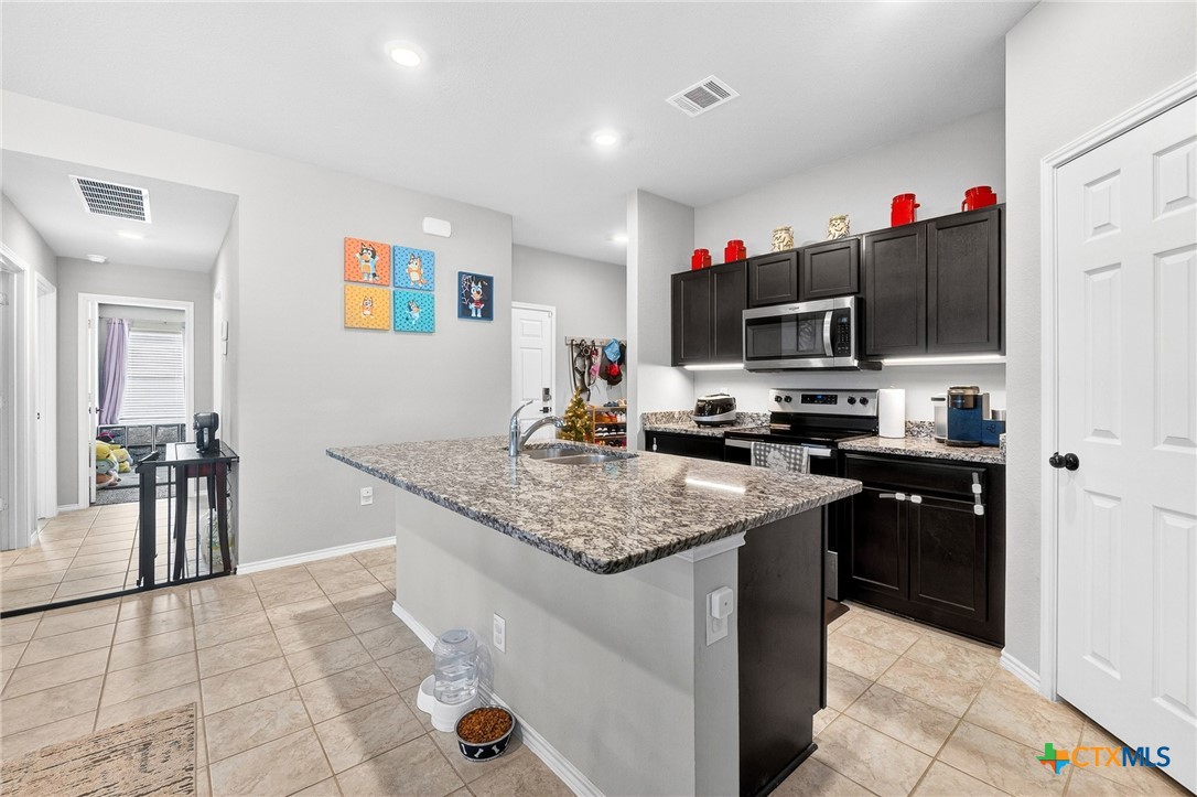 5102 Vivien Street Killeen, TX 76549 - Photo 9 of 23 a kitchen with stainless steel appliances granite countertop a sink dishwasher and a stove with wooden floor