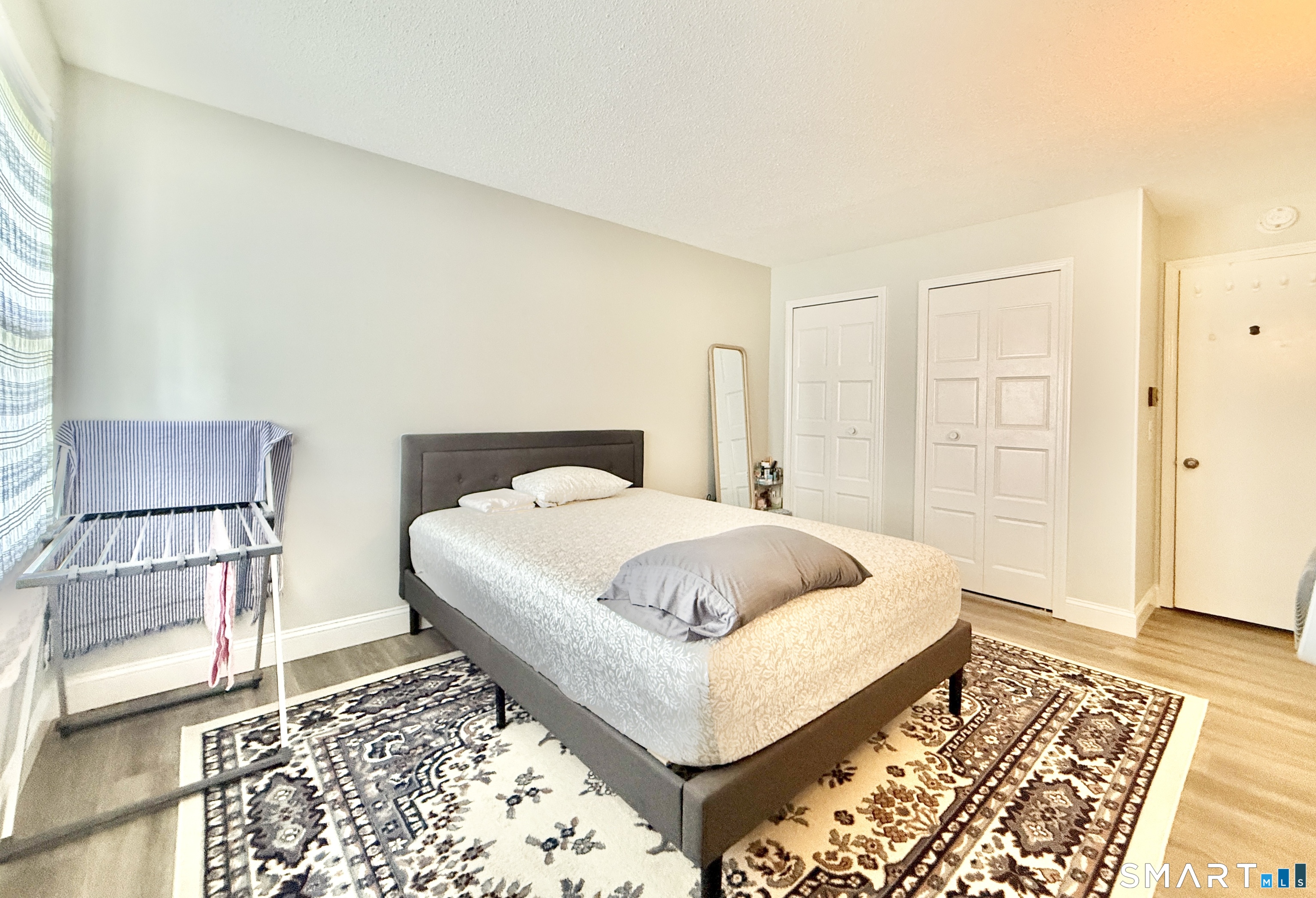 34 A Padanaram Road, Unit 127 Danbury, CT 06811 - Photo 9 of 13 a bedroom with a bed and wooden floor