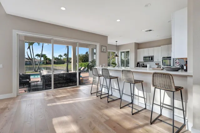 a kitchen with stainless steel appliances a table chairs refrigerator and a sink