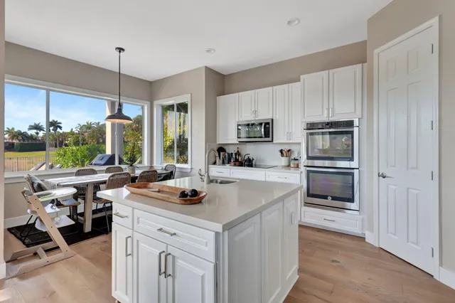 a kitchen with stainless steel appliances granite countertop a sink stove and cabinets