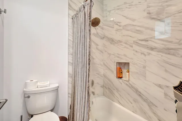 a bathroom with a double vanity sink and mirror with toilet