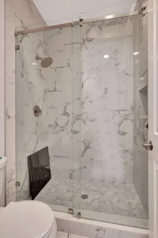 a bedroom with a bed a table and glass door