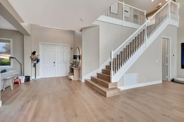 a view of entryway and hall with wooden floor