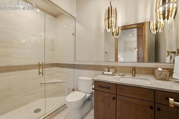 a bathroom with a sink a toilet and shower