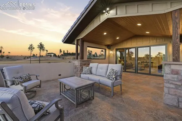 a roof deck with couches and potted plants
