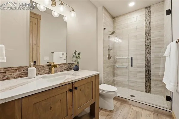 a bathroom with a double vanity sink mirror double shower and a toilet