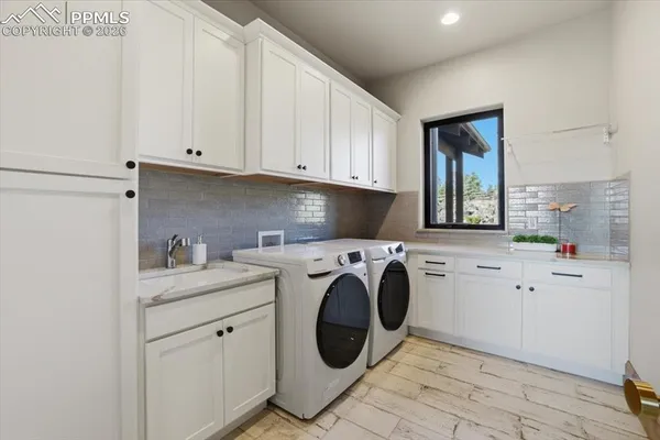 a utility room with sink dryer and washer