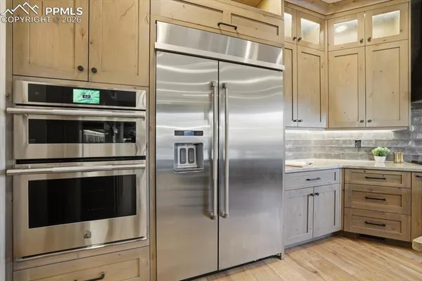a kitchen with stainless steel appliances cabinets and a wooden floor