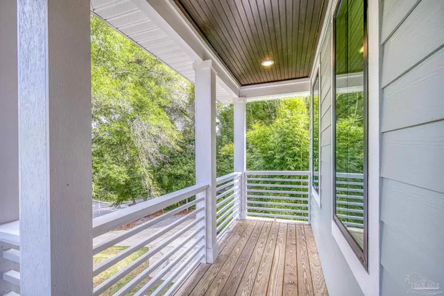a backyard of a house with plants and large tree