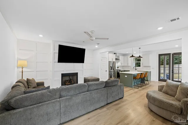 a living room with furniture a fireplace and a flat screen tv
