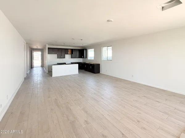 a view of empty room with wooden floor and window