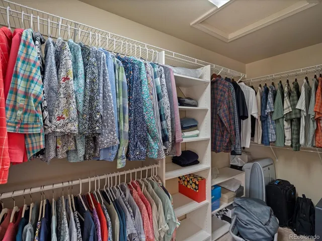 a view of walk in closet with clothes and shoes