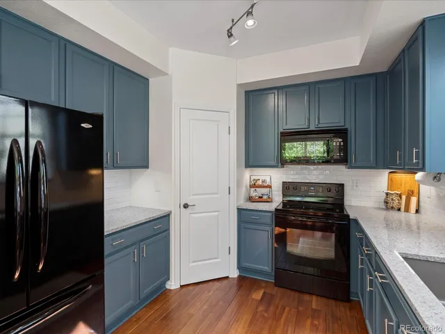 a kitchen with a refrigerator and a stove top oven