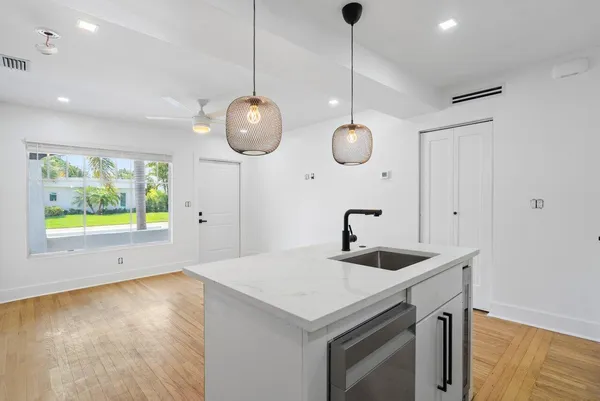 a kitchen with a sink a counter space and a wooden floor