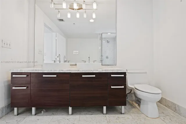 a bathroom with a sink vanity and a toilet