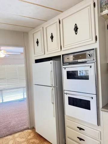 a kitchen with white cabinets and white appliances
