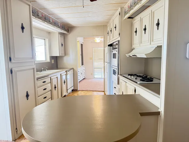 a large white kitchen with stainless steel appliances