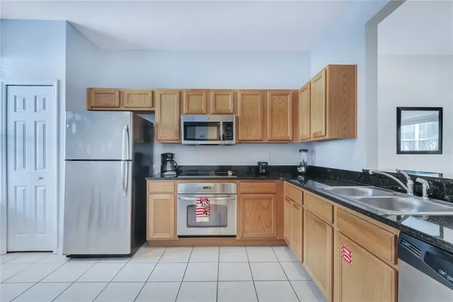 a kitchen with stainless steel appliances granite countertop a refrigerator and a table