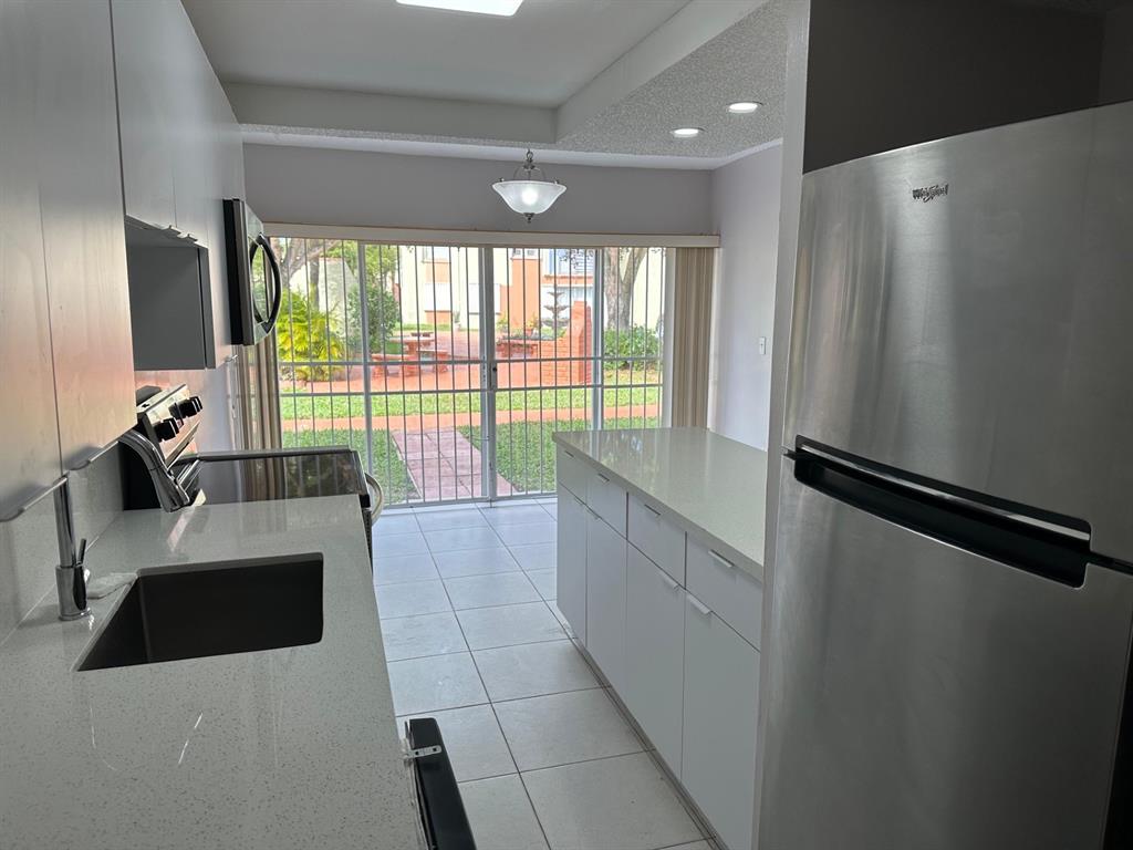 9331 Southwest 4th Street, Unit 104B Miami, FL 33174 - Photo 2 of 11 a large white kitchen with a large window