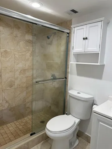 a white toilet sitting next to a bathroom sink