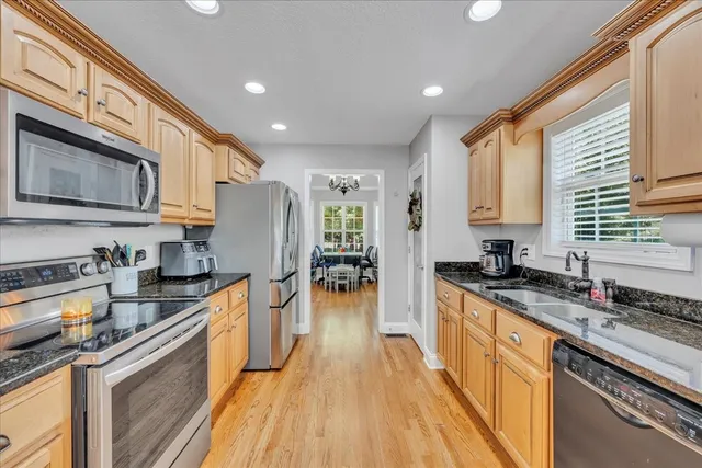 a large kitchen with stainless steel appliances granite countertop a stove a sink dishwasher and a refrigerator