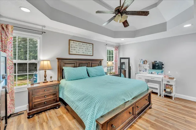 a bedroom with a bed a dresser next to a window