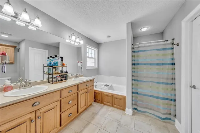 a spacious bathroom with a double vanity sink a mirror and a bathtub