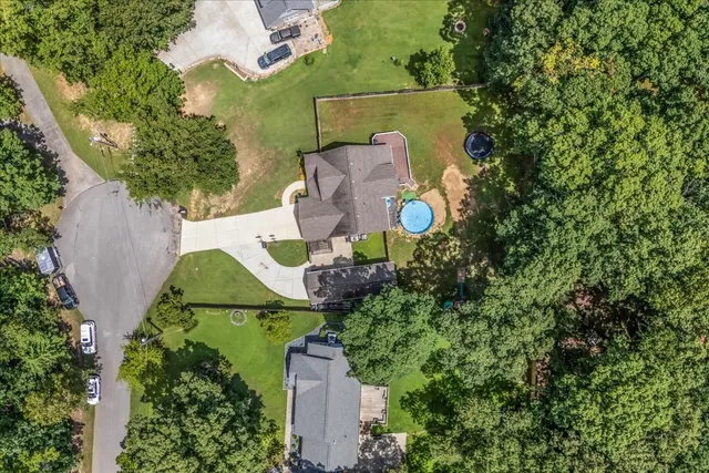 an aerial view of a house with a garden and trees