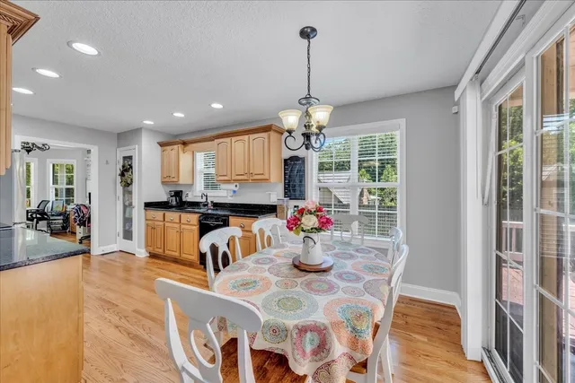 a view of a dining room and livingroom with furniture wooden floor a chandelier