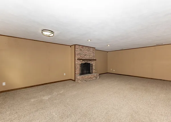 a view of an empty room with a fireplace and a window