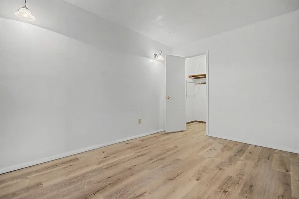 a view of an empty room with wooden floor