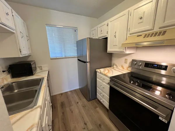 a kitchen with granite countertop a stove and a refrigerator