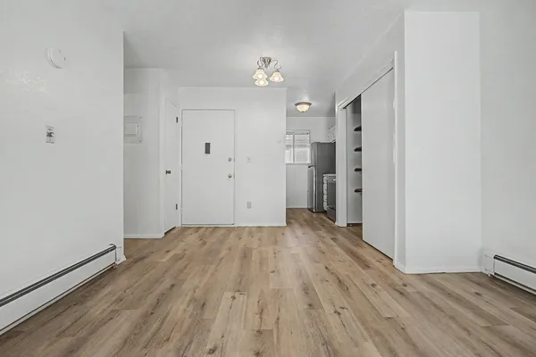 a view of a big room with wooden floor and windows