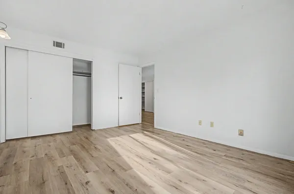 a view of an empty room with wooden floor