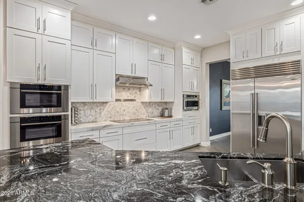 a bathroom with a granite countertop sink a toilet and a mirror