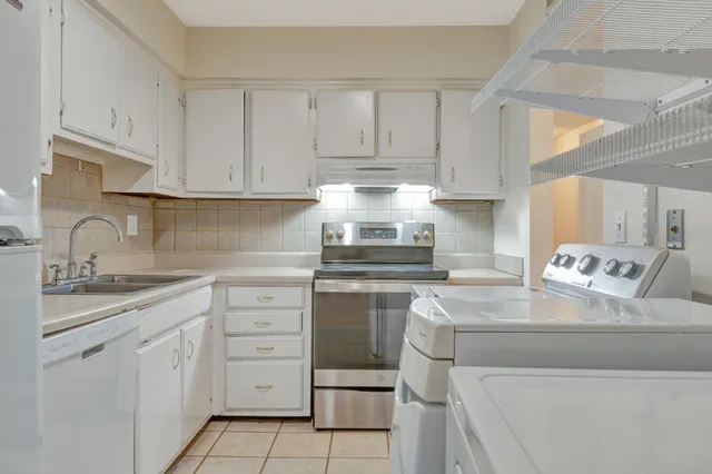 a kitchen with cabinets appliances a sink and a counter top space