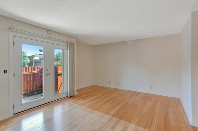 a view of empty room with wooden floor