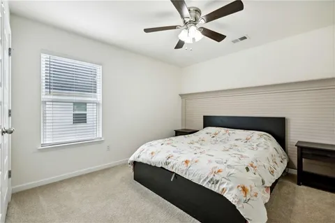 a bedroom with a bed next to a window with a chandelier