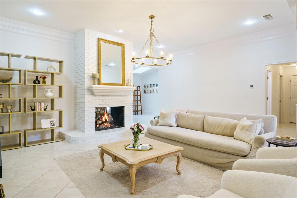 a living room with furniture a fireplace and a chandelier